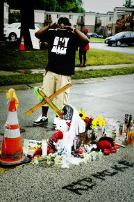 A man pay his respects at the shrine to Mike Brown